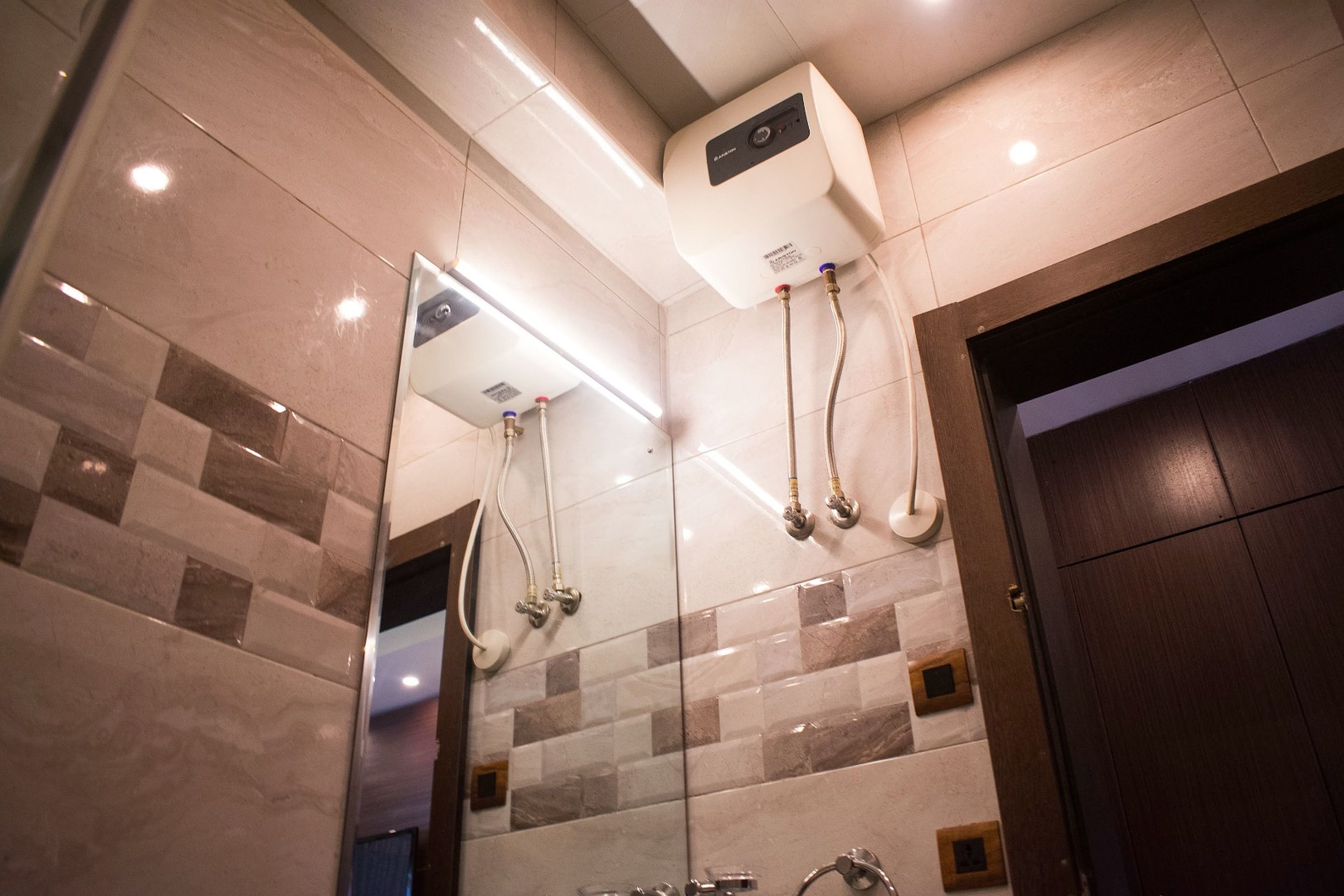 Een moderne badkamer met een douchecabine van glas, een ingebouwde verwarming en een grote spiegel.