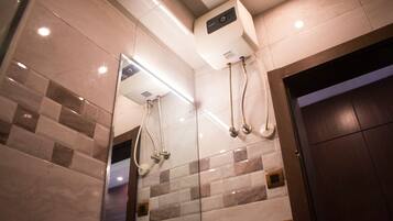 Een moderne badkamer met een douchecabine van glas, een ingebouwde verwarming en een grote spiegel.