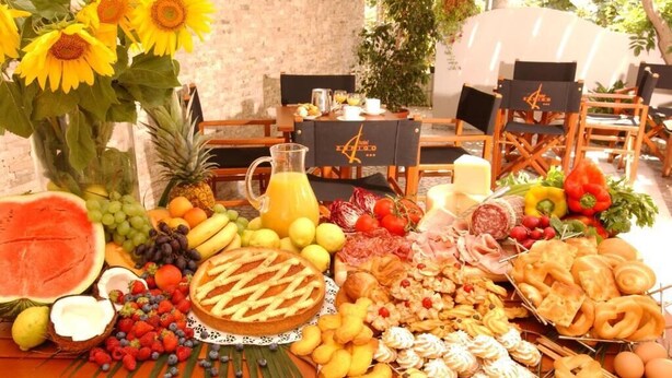 Un bufé de desayuno con una variedad de frutas, pasteles y bebidas.