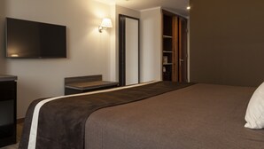 A hotel room with a large bed, a flat-screen TV mounted on the wall, a bedside table, a nightstand, and a wardrobe. - Hotel Diego de Almagro Providencia (Santiago)