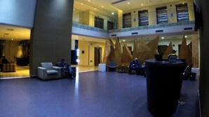 A spacious lobby with a high ceiling, multiple seating areas, and a central decorative feature. - Hotel Diego de Almagro Providencia (Santiago)