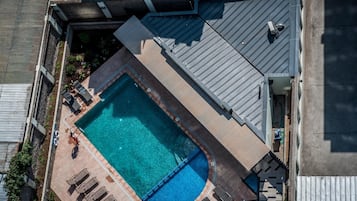 Una piscina al aire libre, tumbonas