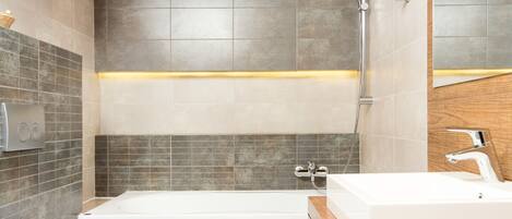 Ein modernes Badezimmer mit Badewanne, Toilette und Waschbecken.