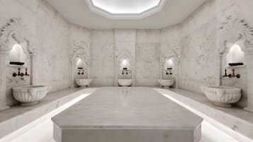 Symmetrical bathroom with a central sink, wall-mounted sinks, and ornate lighting fixtures.