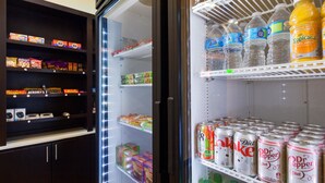 A refrigerator stocked with various food items and beverages, including snacks, drinks, and canned goods. - Best Western Plus Fairview Inn & Suites (Fairview)