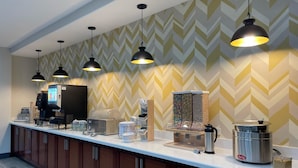 Un espace cuisine moderne comprenant un coin café, une bouilloire et une machine à café.