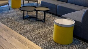 Un salon moderne comprenant un canapé, deux fauteuils, une table basse et une lampe.