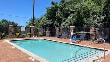 Una piscina al aire libre, sillones reclinables de piscina