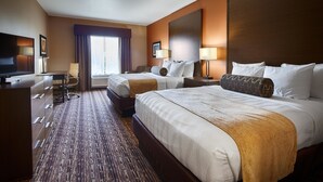 Une chambre d’hôtel avec deux lits, un bureau, une chaise et un téléviseur.