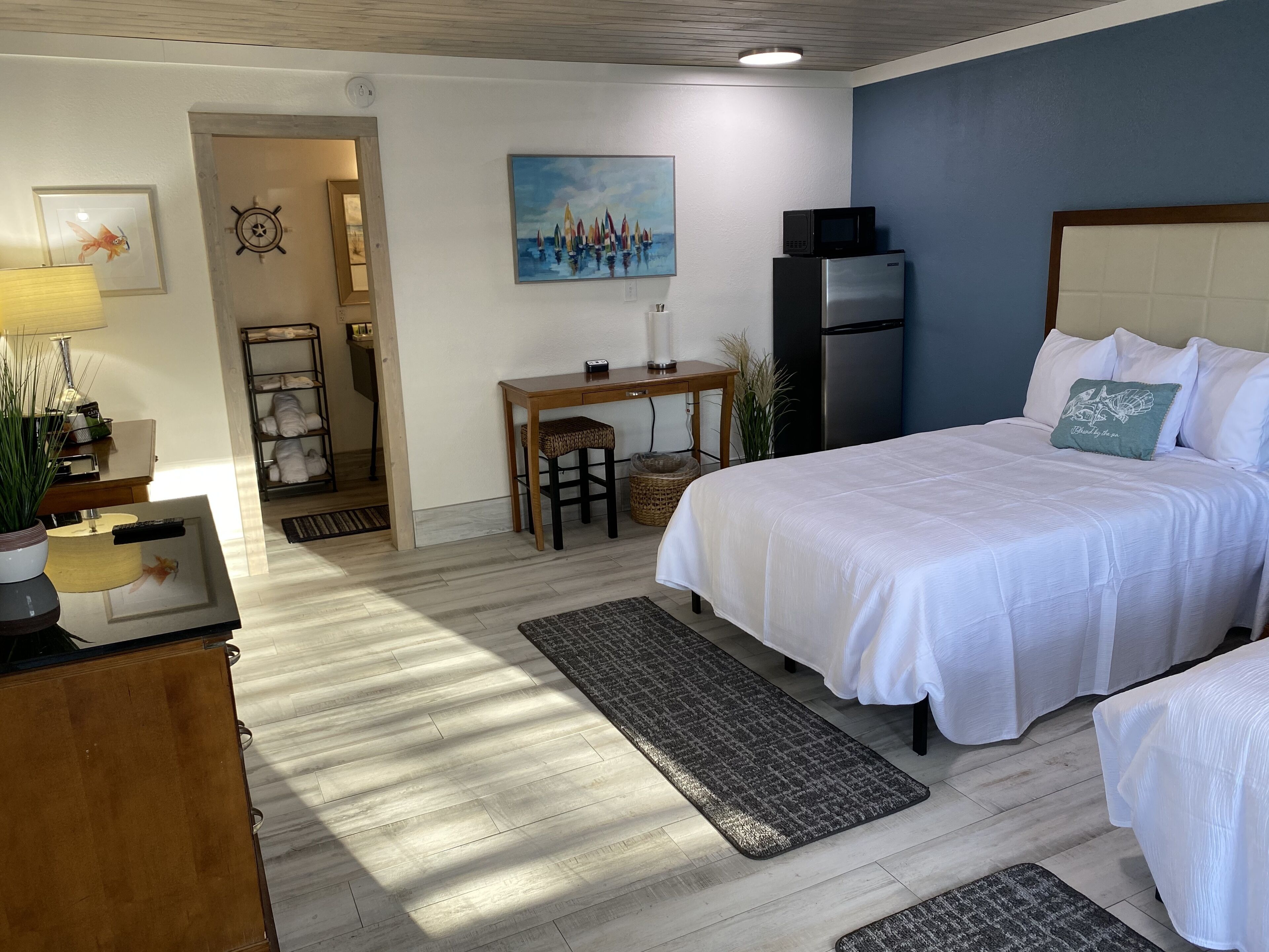 Una camera d'albergo con un letto, un comodino, una lampada e un quadro appeso al muro.