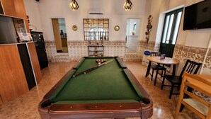 A pool table in a room with a mirror, a television, and a sign for 'The Hostel'. - Guesthouse of Alcobaça (Alcobaça)