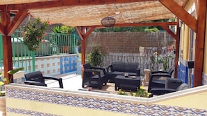 An outdoor patio with a thatched roof, wicker furniture, and tiled flooring. - Guesthouse of Alcobaça (Alcobaça)