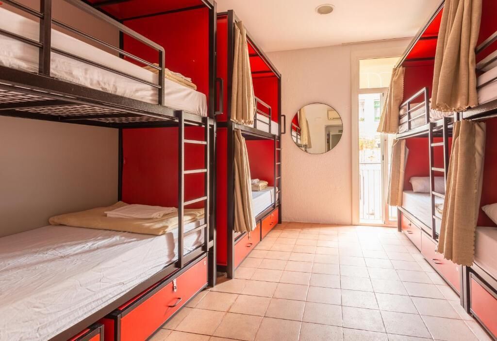 Un dormitorio con literas, un espejo y vistas al exterior.