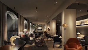 A modern hotel lobby with a long reception desk, comfortable seating areas, and a dining space. - 11 Howard, New York, a Member of Design Hotels (New York)