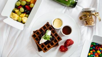 Desayuno con waffles, fruta y salsas.