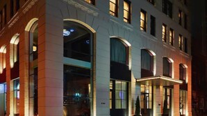 A multi-story hotel with arched windows and a well-lit entrance. - 11 Howard, New York, a Member of Design Hotels (New York)