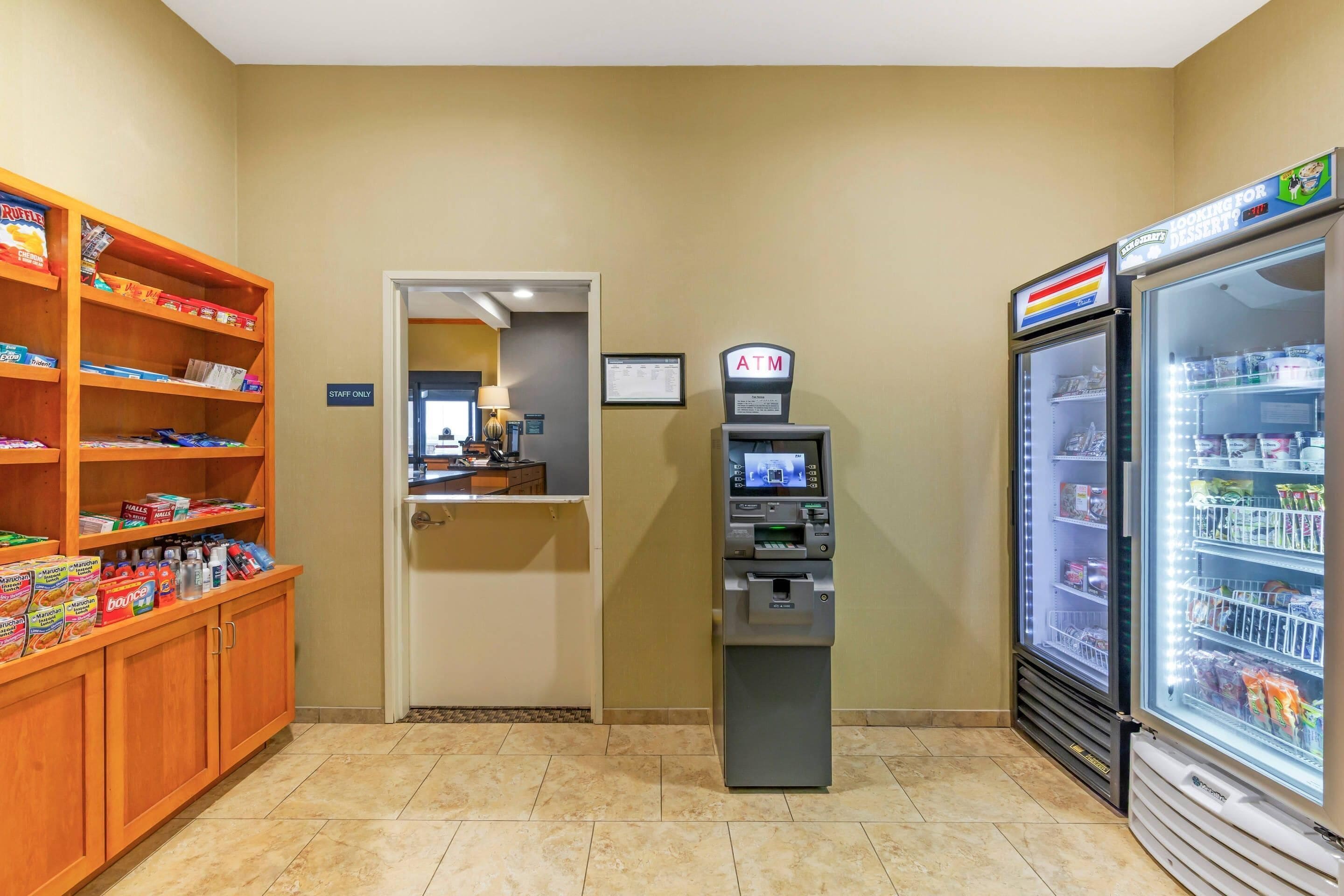 A self-service kiosk, refrigerated display cases, and a snack shelf in a hotel lobby.