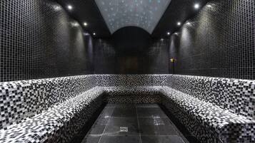 Experience the sleek, geometric design of this modern bathroom, featuring a striking black and white checkered tile pattern and unique ceiling lighting.