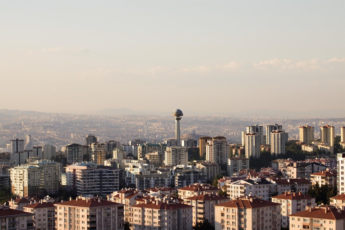 Un paisaje urbano con edificios altos y una torre destacada.