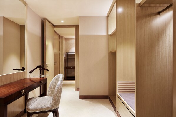 A modern hotel bathroom with a wooden vanity, a mirror, and a patterned chair. - Sheraton Harbin Xiangfang Hotel (Harbin)