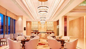 A spacious lobby with a central chandelier, seating area, and a bar with shelves of bottles. - Sheraton Harbin Xiangfang Hotel (Harbin)