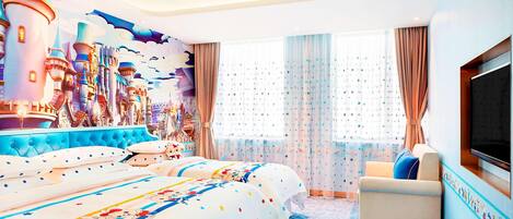 Habitación de hotel con una cama grande, un sofá, un televisor y un mural con motivos de castillo en la pared.