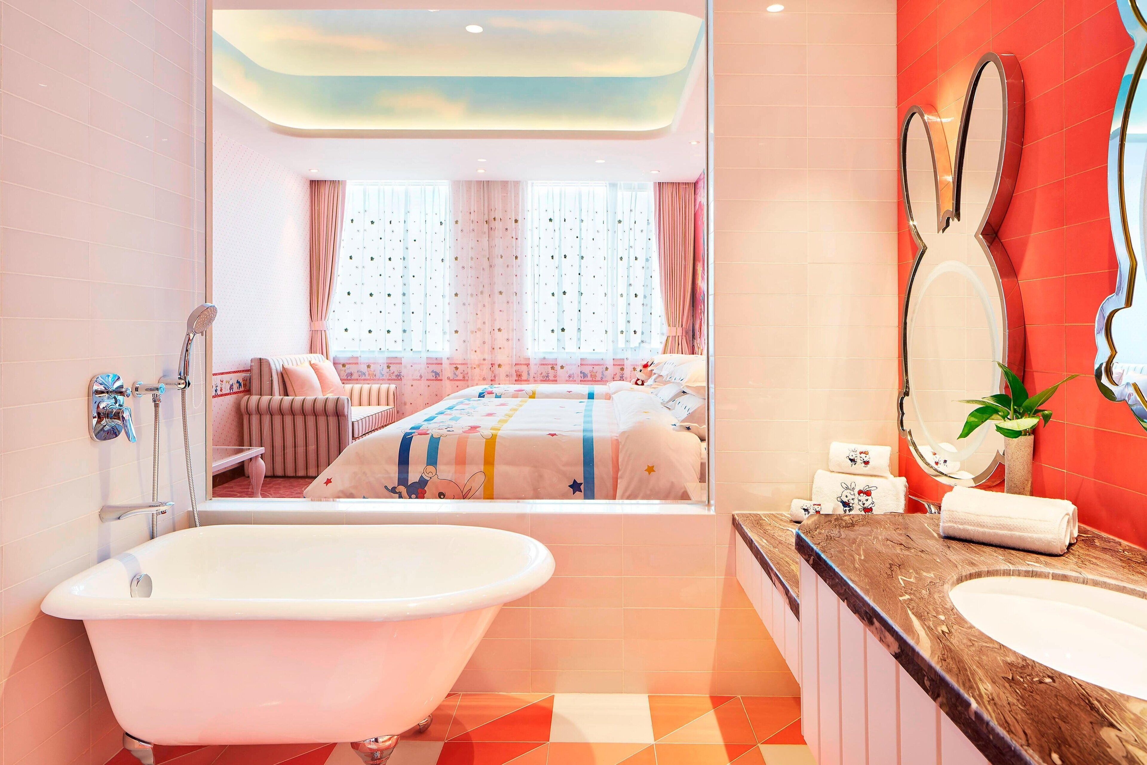 Un baño moderno con una bañera independiente, un espejo grande y un tocador con lavamanos.
