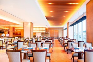 A spacious dining area with multiple tables and chairs, a modern ceiling design, and large windows providing natural light. - Sheraton Harbin Xiangfang Hotel (Harbin)