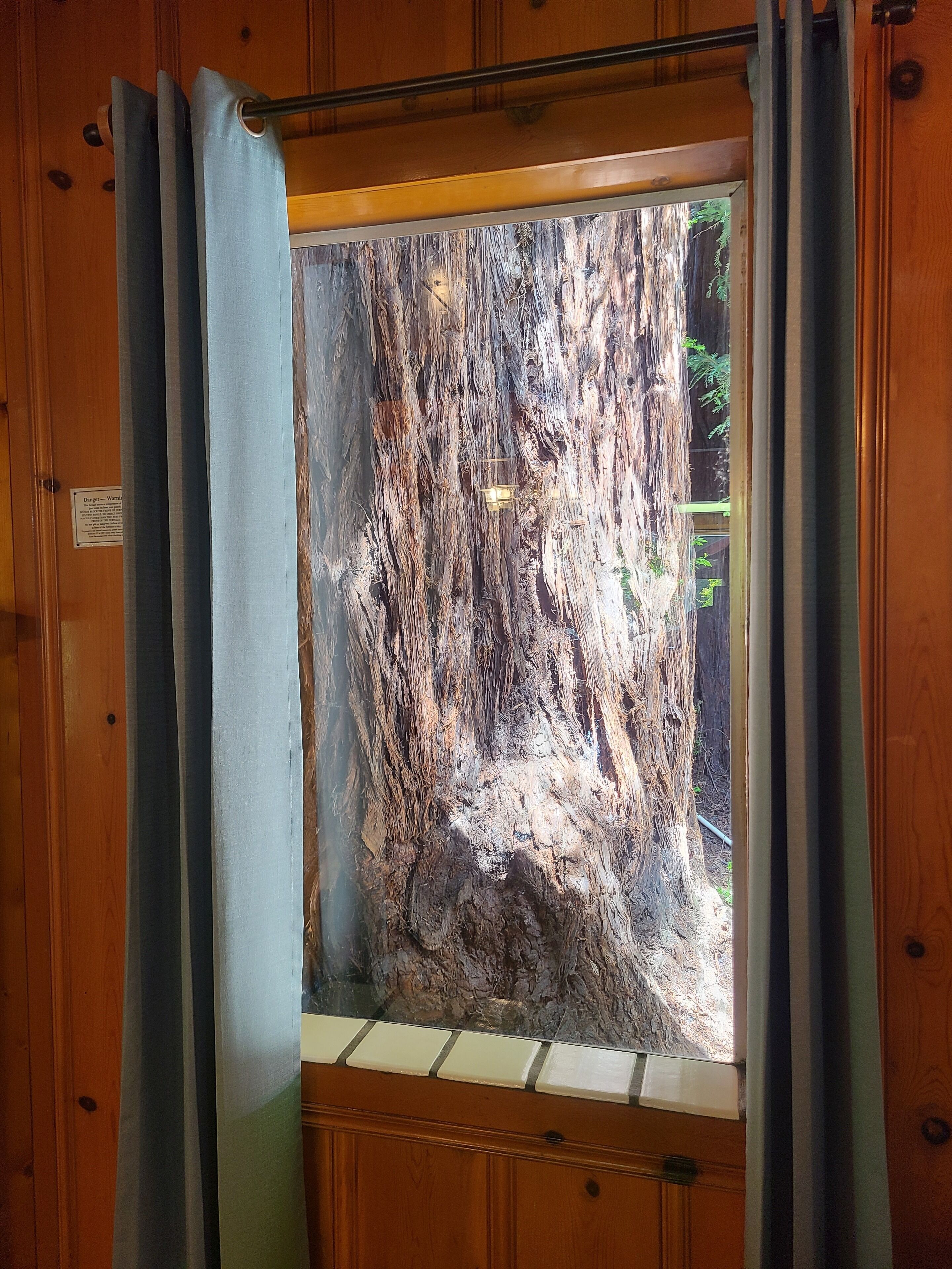 Eine Holztür mit einem Fenster, das eine felsige Landschaft zeigt.