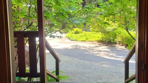 A wooden deck with a view of a garden and a road. - Fern River Resort (Felton)