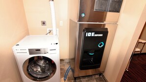 Un espacio de lavandería compacto con una lavadora blanca LG y un dispensador de hielo.