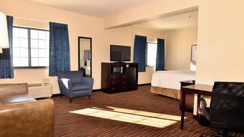 Une chambre d’hôtel comprenant un lit, un bureau, une chaise, une télévision et une commode.