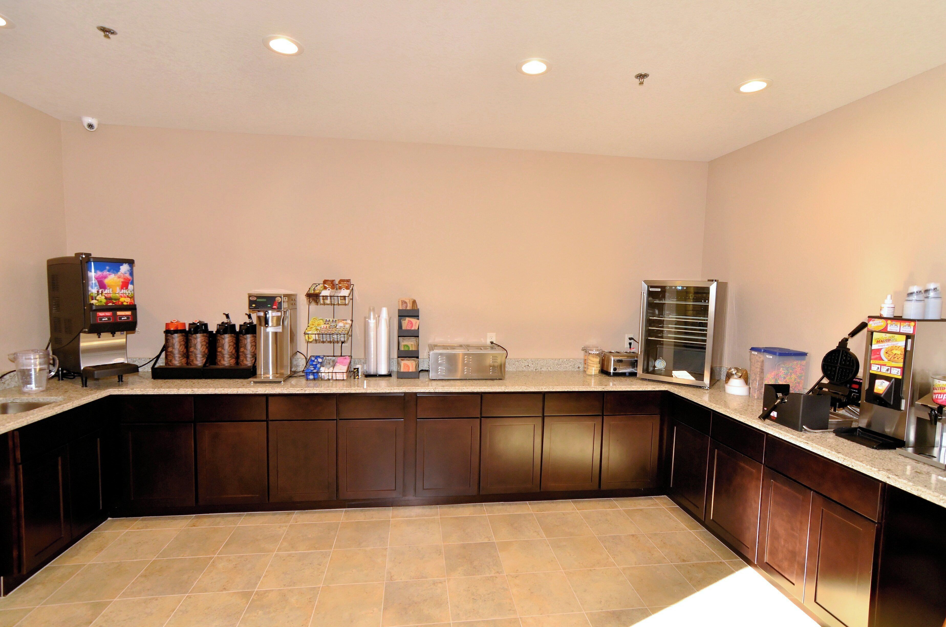 A kitchen area with a coffee machine, toaster, and refrigerator.