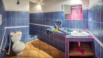 A bathroom with blue tiles, a white toilet, a sink, and a mirror.