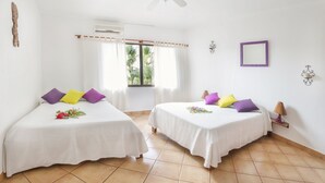A room with two beds, white bedding, and colorful pillows. - Laguna del Cocodrilo (Tamarindo)