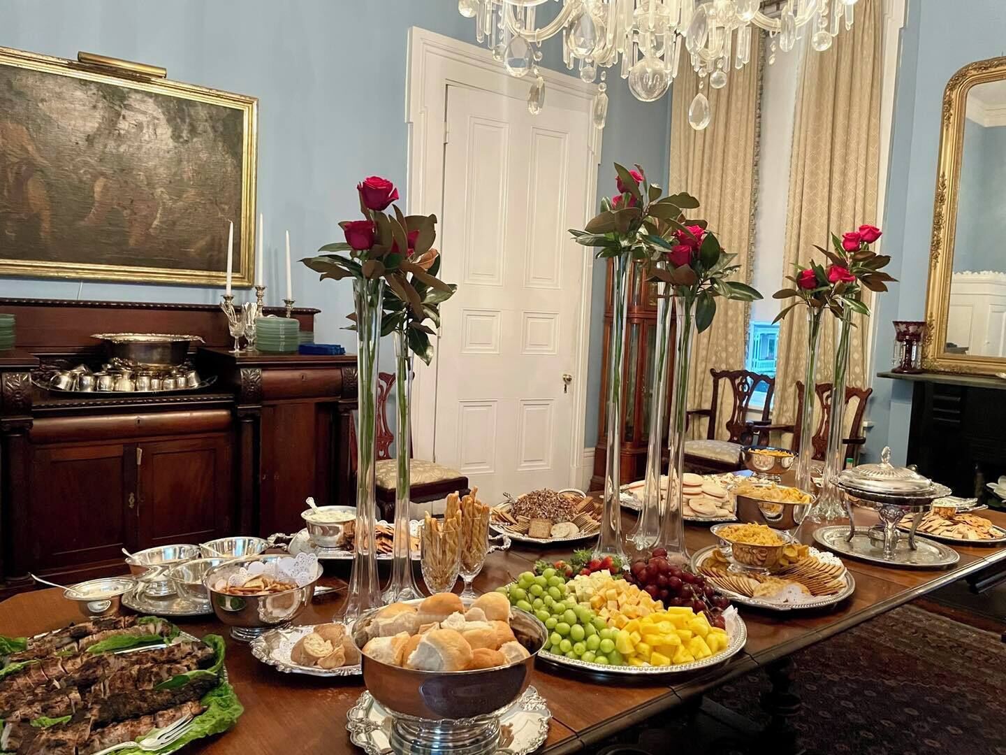 A dining table with various food items and decorative vases.