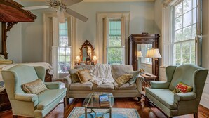 A cozy living room with a sofa, two armchairs, a coffee table, and a ceiling fan. - Duff Green Mansion (Vicksburg)