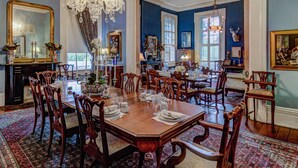 A formal dining room with a large wooden table set for a meal, surrounded by ornate chairs. - Duff Green Mansion (Vicksburg)