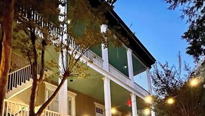 A two-story building with a balcony, outdoor seating area, and a fountain. - Duff Green Mansion (Vicksburg)