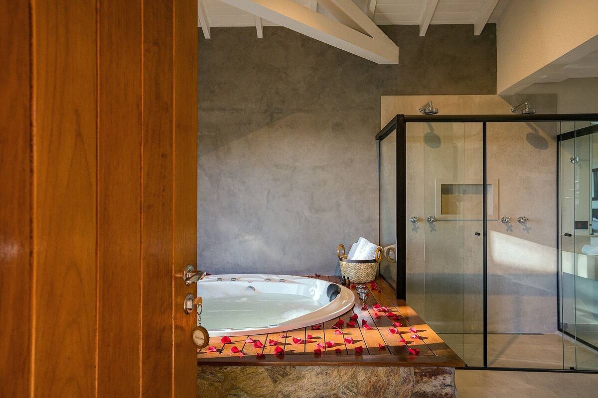Une salle de bain moderne avec une baignoire sur pieds, une douche à parois de verre et un meuble-lavabo en bois.