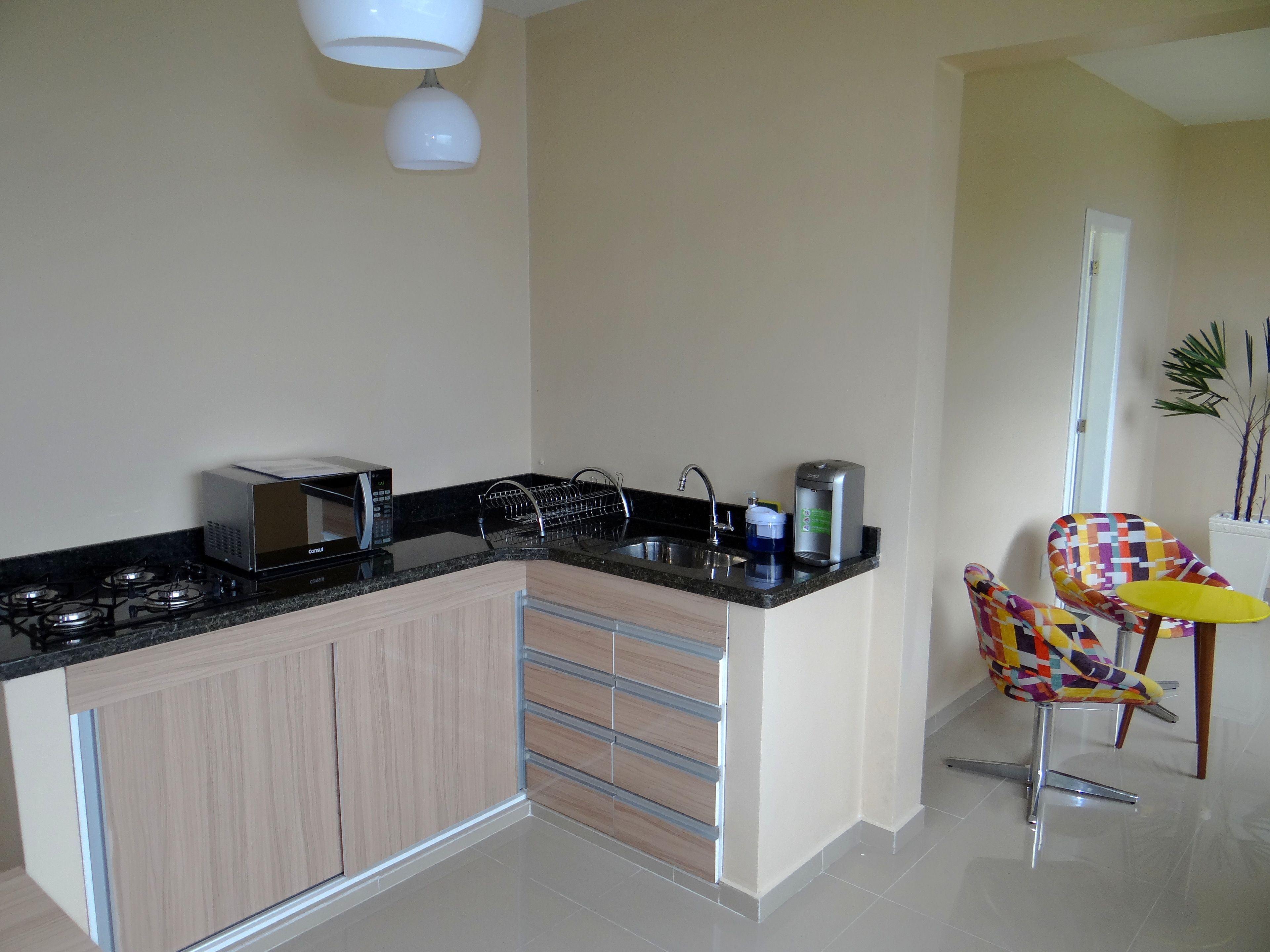 A modern kitchen with a built-in gas stove, a microwave, a coffee maker, and a dish drying rack.