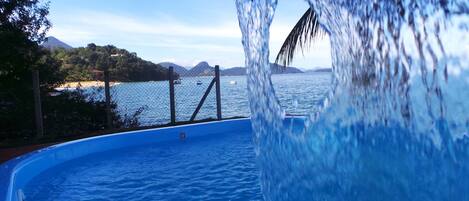 Una piscina con vista despejada al mar y montañas lejanas.