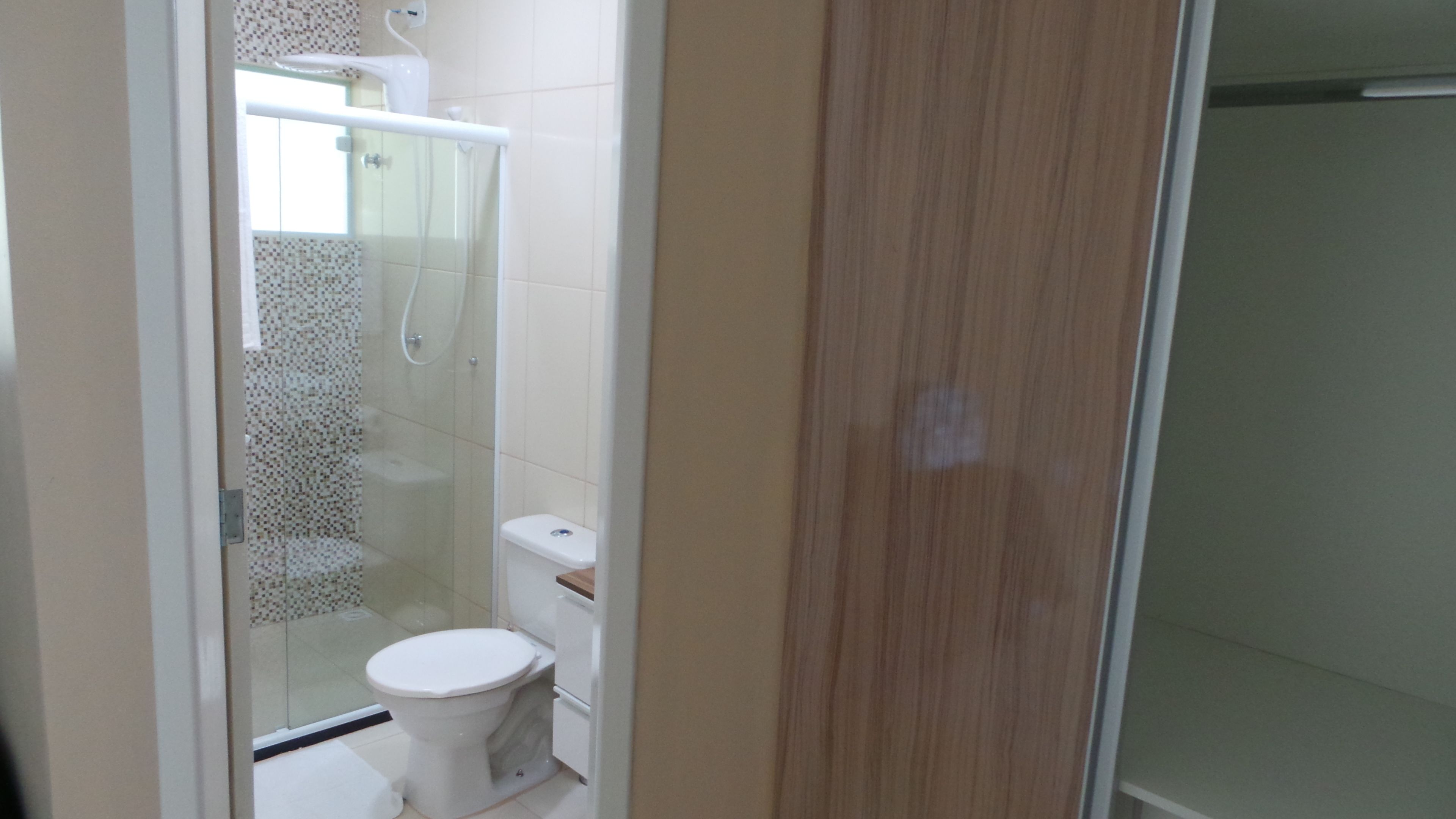 Un baño con inodoro, cabina de ducha y puerta de vidrio.