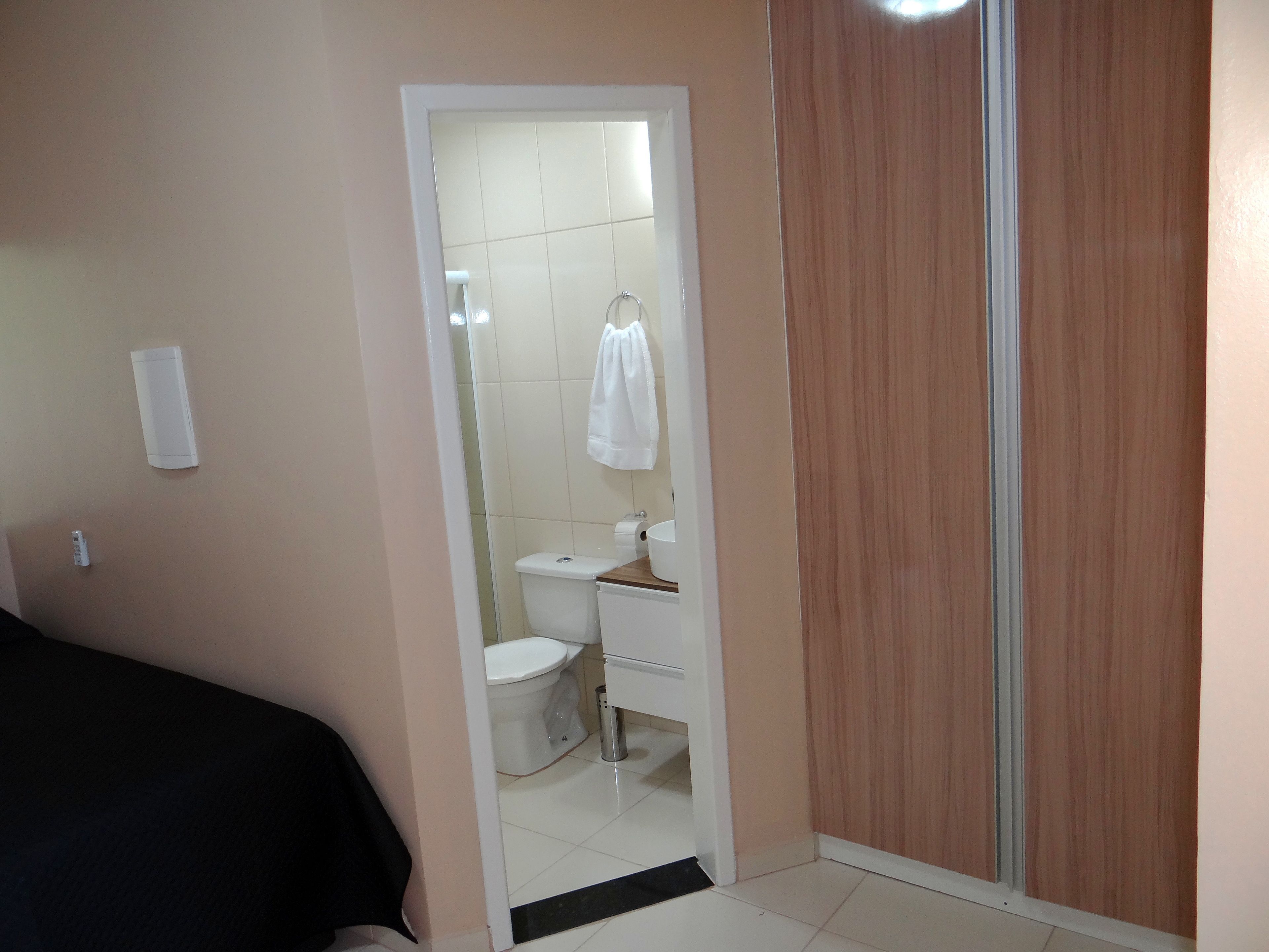 Un baño con inodoro, lavamanos y espejo.