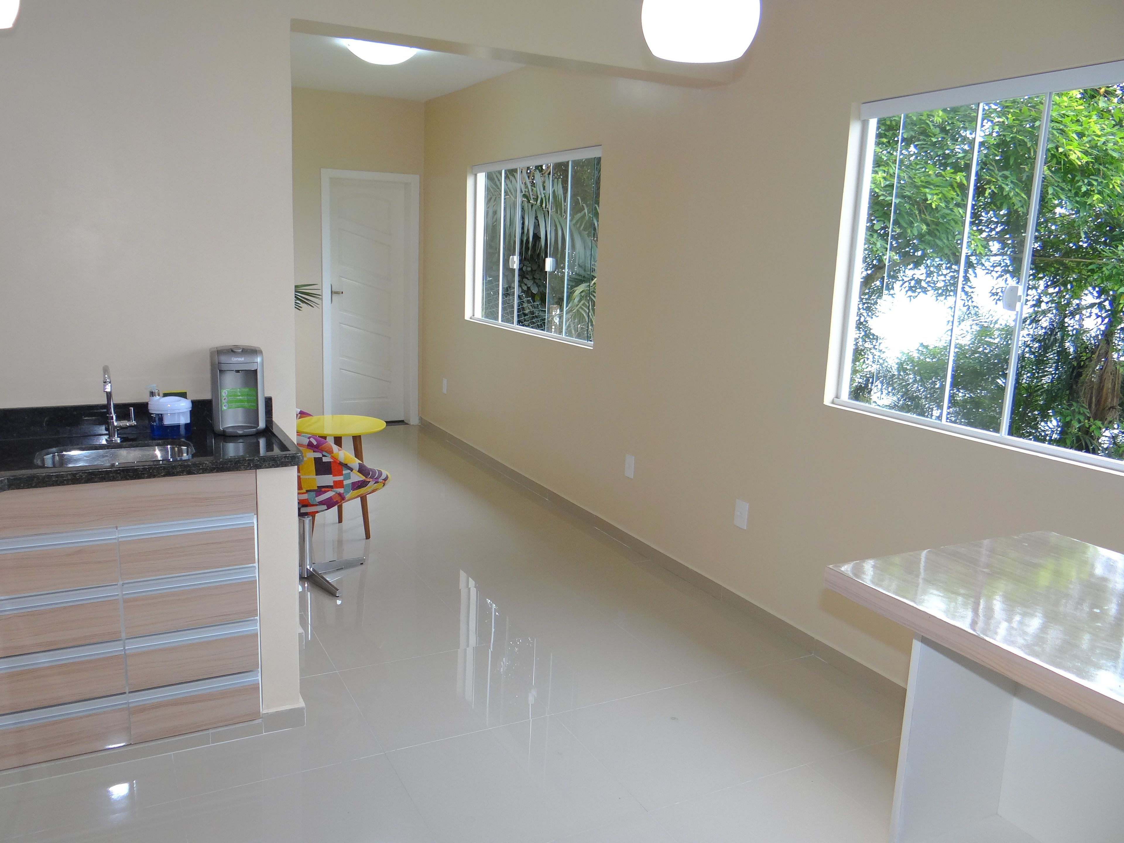 A kitchen with a sink, a coffee maker, and a chair.