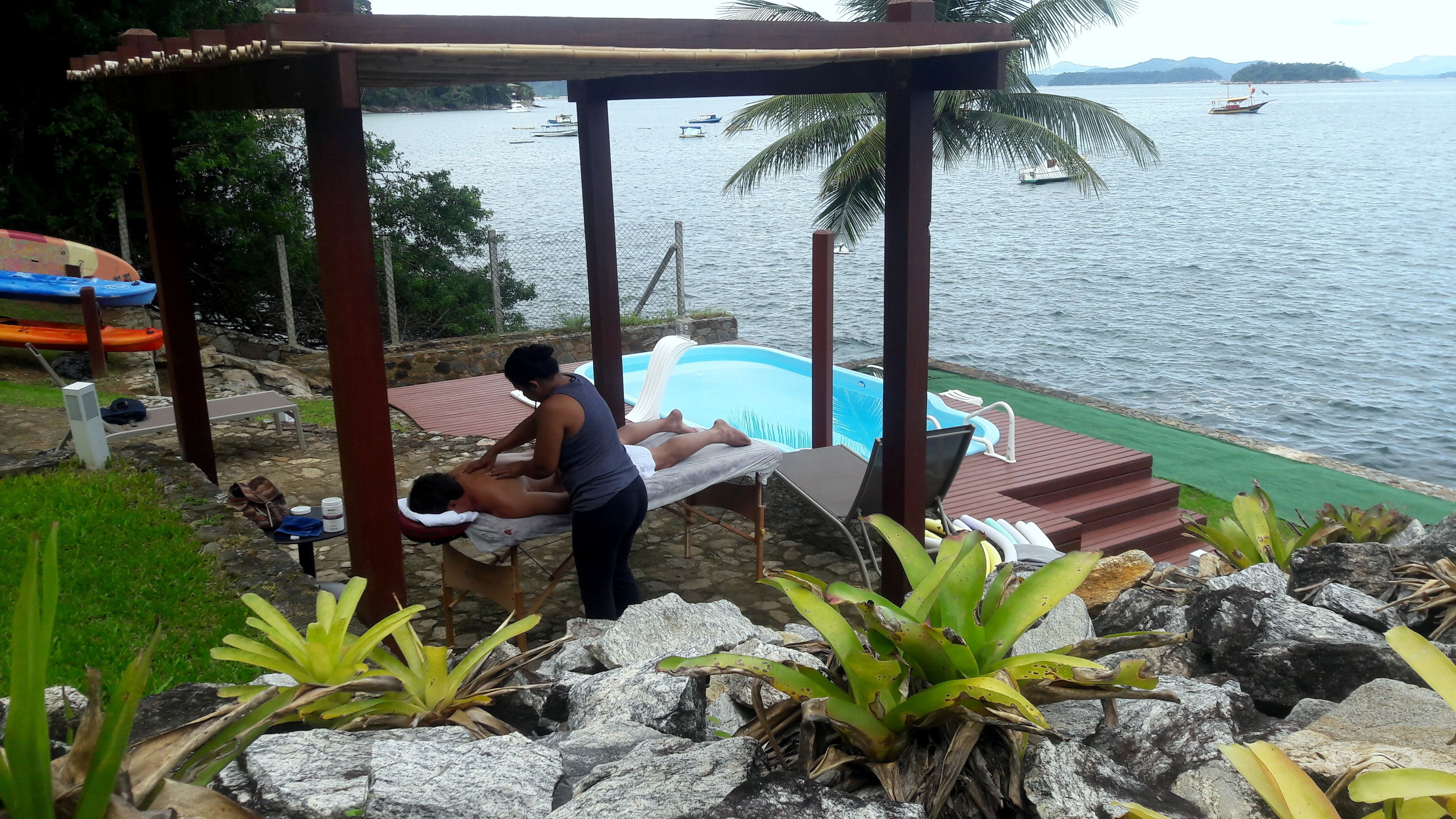 A massage area with a pool, overlooking a body of water with boats.