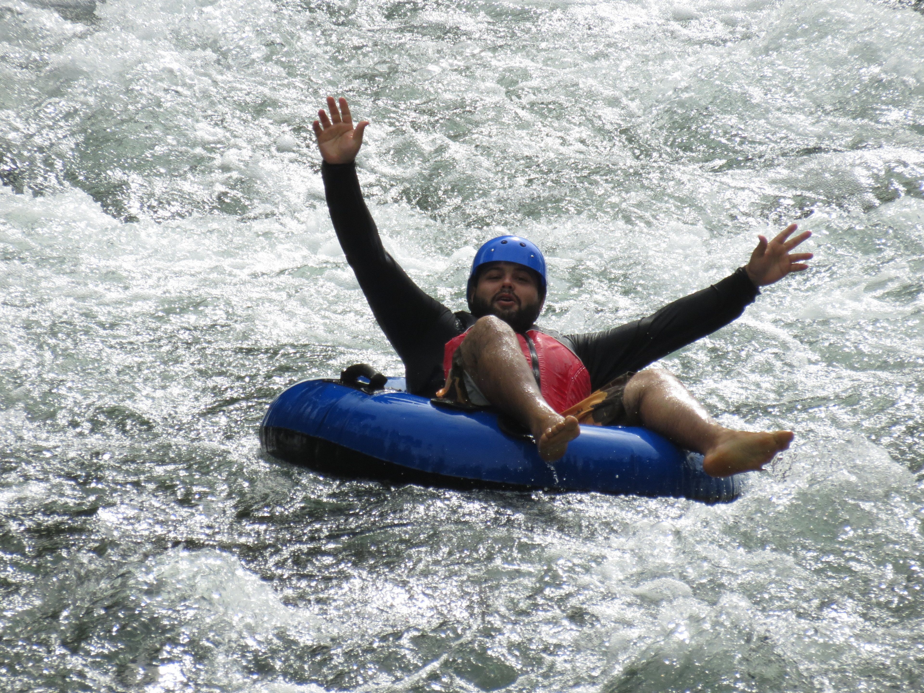 Una persona en una balsa inflable azul en un río.