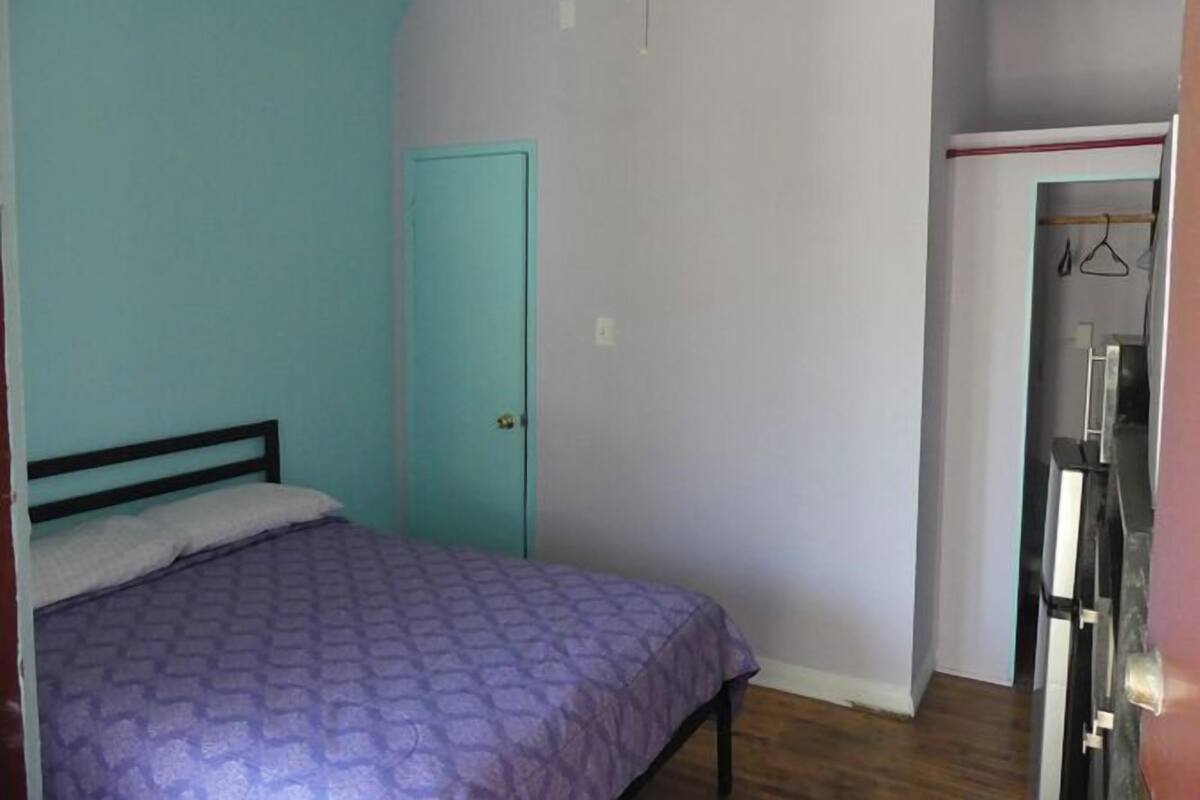 Ein Schlafzimmer mit Bett, Tür und Kleiderschrank.