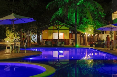 Una piscina al aire libre, sillones reclinables de piscina