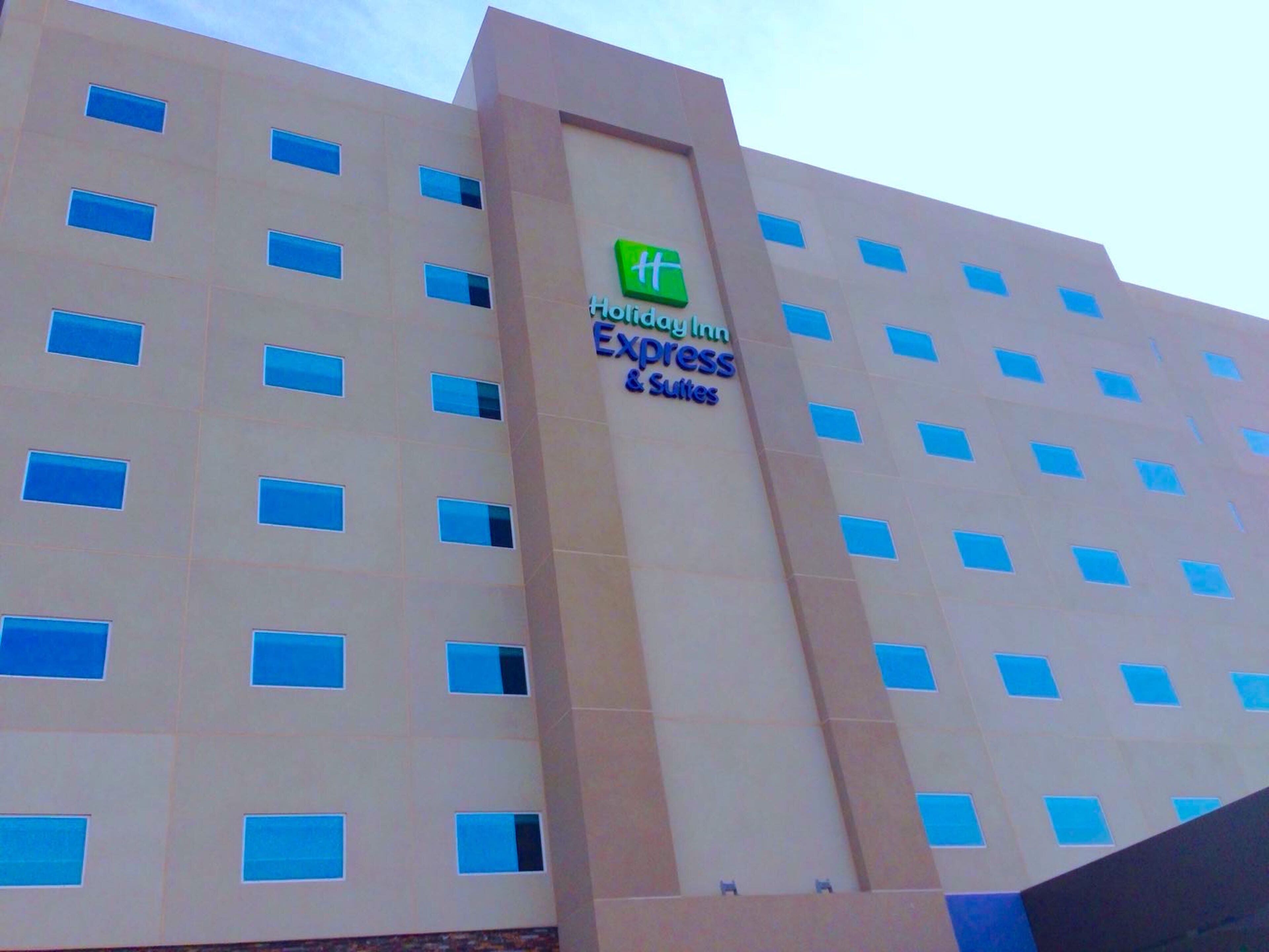 Un edificio de hotel con un letrero que dice 'Holiday Inn Express Suites'.